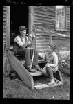 Older Man Sitting On Steps While Stringing A Bow For A Young Boy "Tots- Don And Grandpa-Bow" by George French