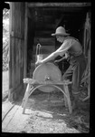 Man Sharpening Scy Blade On An Old Grinding Wheel. by George French