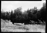 Double Ended Rowboat Pulled Up On River Shore. by George French