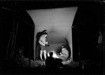 Two Men Cooking Fish Over Fire By Tent At Night by George French