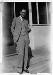 Full Length Photo Of A Man Holding A Cigar And Standing On A Porch by George French