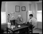 Doc Ridlon In His Office In Kezar Falls With A Patient by George French