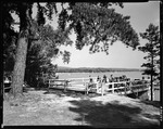 People Relaxing On Dock Over The Water At Goodwin's Lodge In North Sebago by George French