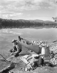 Man About To Cook Fish Over Campfire At Kezar Lake, Mountains In The Distance by George French