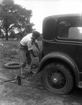 Man Changing Tire On Vintage Auto ('20 Or '30 ) by George French