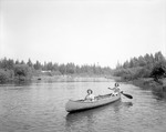 Two Girls Paddle Canoe Up Cross Lake Stream, Others Afar by George French