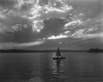 Canoe With A Sail On Long Lake In Naples, Nice Clouds In Sky, Mountains In Distance by French George
