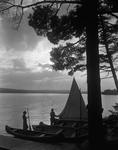 Canoes And Small Sailboat Pulled Up On Shore, Couple Getting Ready To Go Out Sailing, Nice Lighting by French George