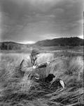 Duck Hunter In Tall Grass With Gun At The Ready by French George