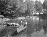 A Couple Canoeing On Kezar Lake, Camps In Background by French George