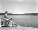Two Young Women Sitting On A Dock At A Lake In Canton At Pinewood Camps by French George