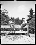 Two Boys Sitting On Wooden Bridge Making Alder Fish Poles In Parsonsfield by French George