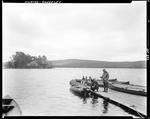 Man Getting Ready To Go Out Fishing While Talking To Another On A Dock At Pleasant Island, Rangeley by French George