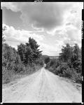 Gravel Road, In Casco, Leading Toward Distant Body Of Water by French George