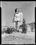 Young Woman Wearing Shorts, Tank Top And Ski Boots Standing In Snow by George W. French