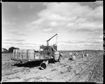 Worker Off Loading Barrels In A Potato Field And Picking Up Full Ones At Caribou by George French