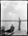 Two Men Fishing, One From Canoe, One From Dock At Lake Kezar by George French