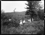 Family Walking Through Tall Grass Toward A Lake, They Are Carrying Fixings For A Picnic by George French
