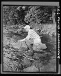 Man Standing In Stream Unhooking Fish by George W. French