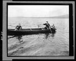 Two Men Fishing From A Canoe, One Netting Fish For The Other At Fish River Lake by George W. French