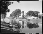 People Fishing From Shore On Lake Inlet, Large Homes And Trees In Background In Jefferson by George French