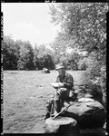 Man Sitting On Rocks Near Stream Holding Fish He Caught At Kimball Falls In Porter by George French