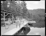Teenaged Girls, In Bathing Suits, Near And Walking In Front Of A Canoe Storage Rack At A Camp In Hiram by George French