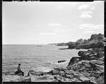 Young Boy Fishing Off Rocks On Shore In South Portland by George French