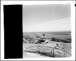 Man Sitting On Rock On Cadillac Mountain In Acadia National Park, View Of Bay In Background by George French