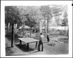 Young Couple Playing Ping Pong Outdoors Near A Camp by George French