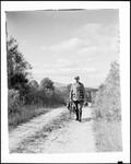 Hunter And Dog Walking Down A Dirt Road, Mountains In Background by George French