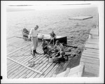 Man On Dock Dumping Bait Into A Bait Can Getting Ready For Fishing by George French