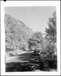 Car Parked Alongside Highway At The Base Of A Steep Hill by George French