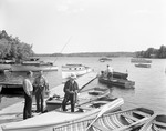 Two Men On A Dock Talking, One Man In A Boat Holding Fish He Caught, Another Man Getting Ready To Go Fishing At Sebago by George French