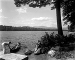 Man On Dock Holding Bow Of Canoe, Woman Sitting In Canoe At Lake Kezar by George French