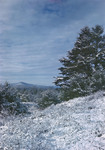 Snow Covered Hillside With View Of Distant Mountain by George French