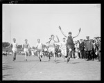 Runners Crossing The Finish Line In A Race At A Track Meet by George French
