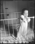 Baby Standing In A Crib by George French