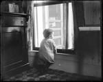 Young Child Standing And Looking Out Of A Window by George French