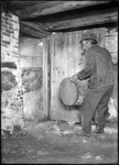 Man In A Cellar Smoking A Pipe And Carying A Barrel by George French