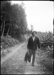 Man (George French) Walking Down Rural Road Carrying A Fishing Pole And Days Catch by George French