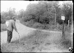 Man With Walking Stick And Bundle Stands At Crossroad Looking At Sign 'kezar Falls 2mi' by George French