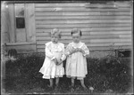 Two Young Children Standing Outside A Home by George French
