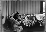 Young Boy Sleeping In Bed With A Young Girl Sitting At The Bedside by George French