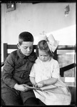 Young Boy & Girl Reading A Book Together by George French