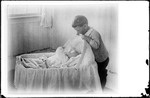 Young Boy Playing Peek-a-Boo With A Baby In A Crib by George French