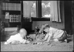 Young Boy And A Baby Playing With Toys On The Floor by George French