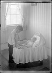 Young Boy Looking At A Baby In A Bassinet by George French