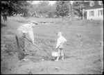 Father And Son Planting A Small Garden by George French