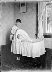 Young Boy Looking At A Baby In A Bassinet by George French